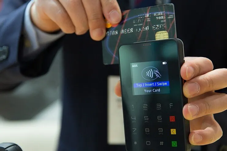 A guest tapping a card on a payment terminal